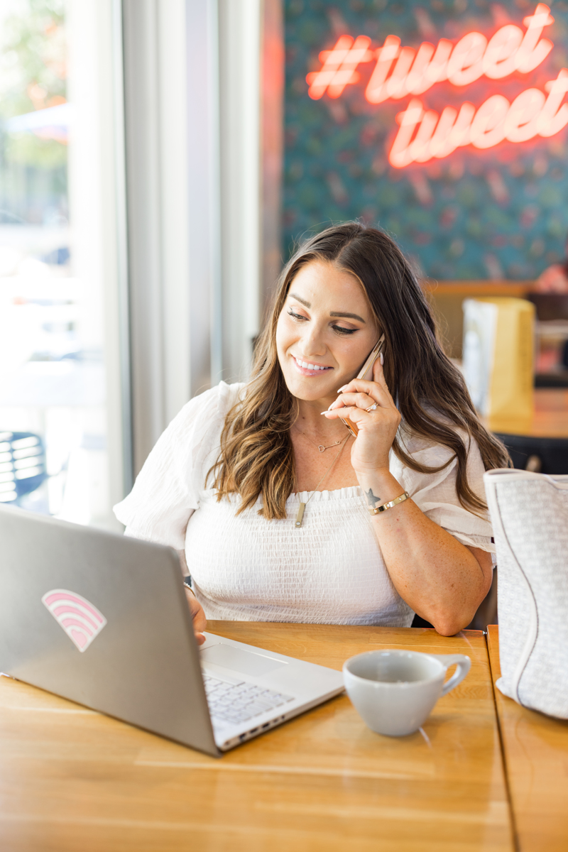 Valli Lopez speaking with a client while working at her laptop
